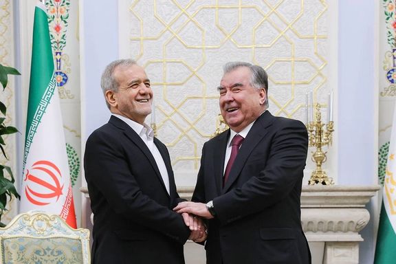 Iranian President Masoud Pezeshkian and Tajik President Emomali Rahmon shake hands