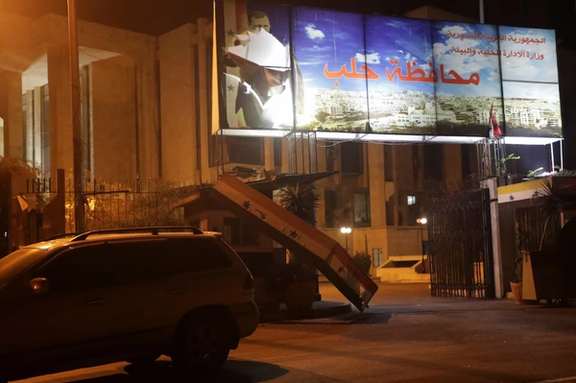 A car is parked near a ripped poster of Syria's President Bashar al-Assad, after rebels opposed to President Bashar al-Assad said they had reached the heart of Aleppo, Syria November 30, 2024.