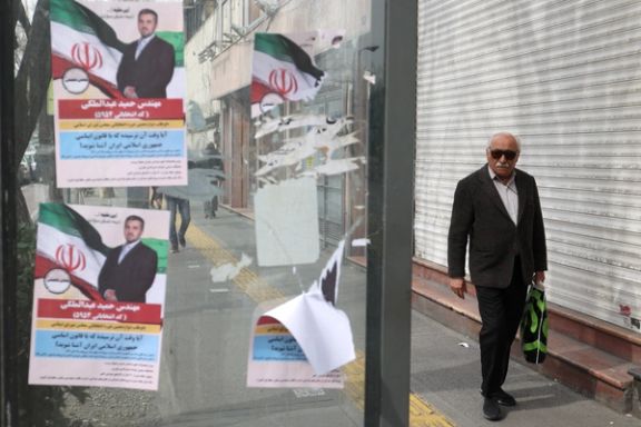 An Iranian man walks past campaign posters for the parliamentary election in Tehran, Iran, February 24, 2024.