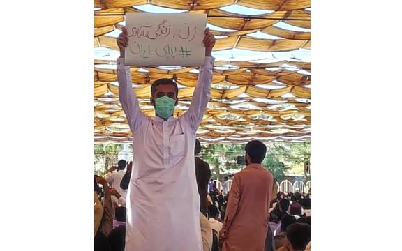 پلاکارد «زن، زندگی، آزادی» در دستان یک شهروند در نماز جمعه زاهدان