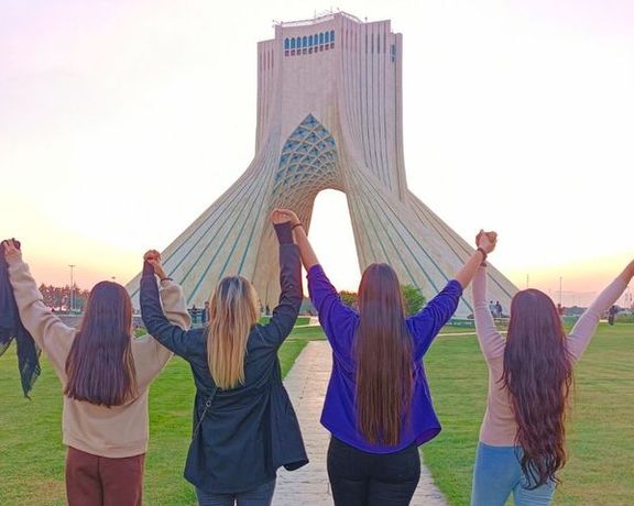 Several Iranian women remove their headscarves in front of Tehran’s iconic Azadi tower, formerly known as the Shahyad Tower.