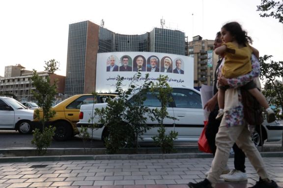 A billboard with a picture of the presidential candidates is displayed on a street in Tehran, Iran, June 17, 2024.