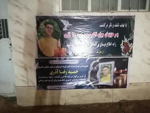 تصویری از بنر بر دیوار منزل خانواده حمیدرضا آذری «کودک-مجرم» اعدامشده