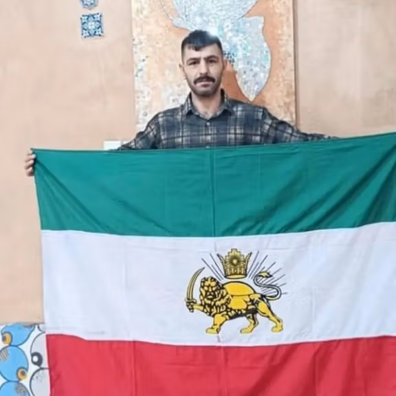 Abol (Hamid) Korkor with Iran's ancient flag with the Lion and Sun emblem