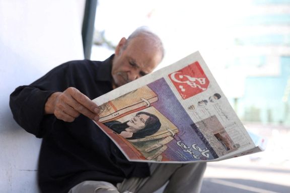 A man views a newspaper with a cover picture of Mahsa Amini in Tehran