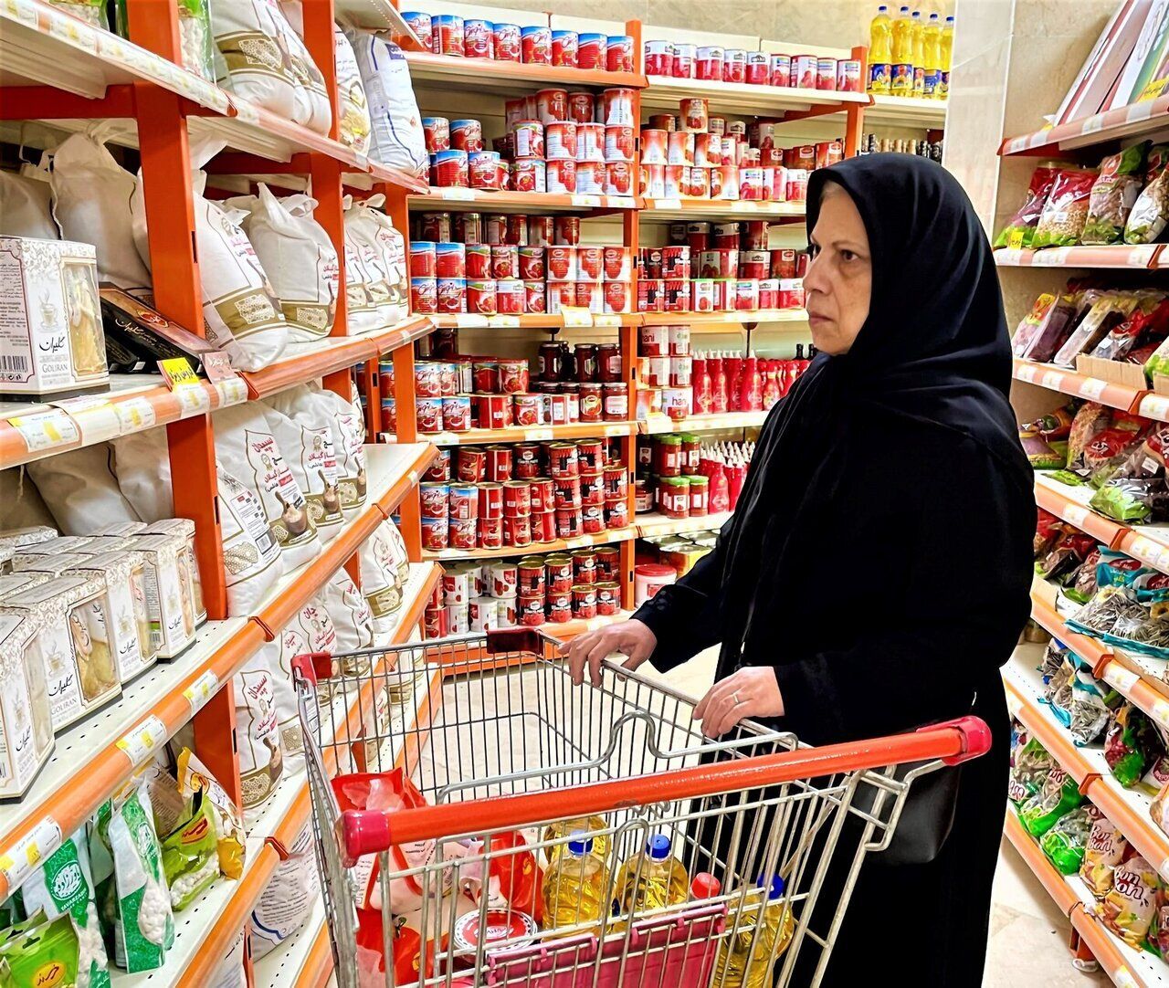 An Iranian shopper browses staple goods in a supermarket as inflation continues to erode purchasing power, pushing food prices further out of reach for many households.
