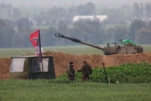 Israeli soldiers stand at an artillery position, amid the ongoing conflict between Israel and Iran-backed Islamist group Hamas, near the Israel-Gaza border, as seen from Israel, February 19, 2024.