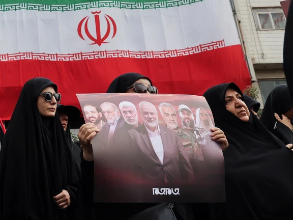 An Iranian woman holding a poster of Hamas leader Ismail Haniyeh during a symbolic funeral procession in Tehran, (August 2024)