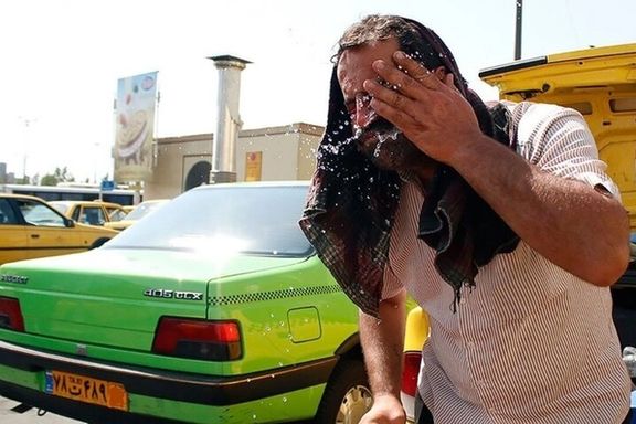A taxi driver splashes water on his face to find relief from the intense heat during a heatwave in Iran