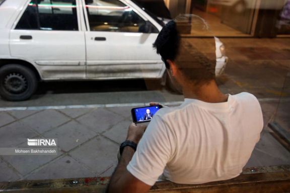 An Iranian man watching the presidential debate on his mobile phone (June 2024)