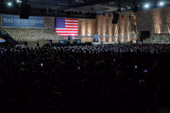 US President Donald Trump delivers remarks to U.S. troops, next to a banner reading, "Peace Through Strength", during a visit to Al Udeid Air Base in Doha, Qatar, May 15, 2025.
