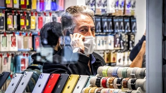 An Iranian man talking on his phone inside a cellphone store in Tehran (file photo)