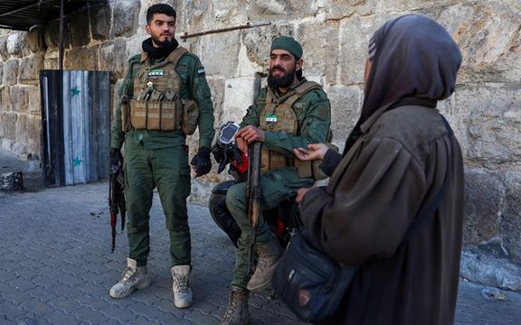 دو تن از اعضای گروه مسلح حاکم بر دمشق در یکی از خیابانهای این شهر، ۲۹ آذر