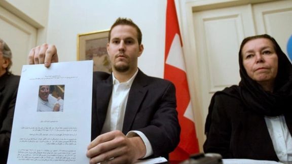 Christine Levinson (right), wife of former FBI agent Robert Levinson, watches as her son Daniel Levinson displays a web print of his father's picture to journalists while attending a news conference at Switzerland's embassy in Tehran December 22, 2007.