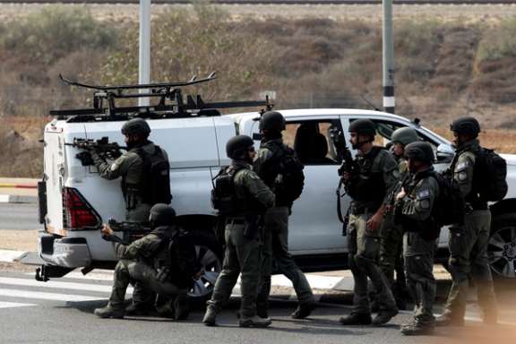 Israeli security take position on a road following a mass infiltration by Hamas gunmen from the Gaza Strip, near Sderot in southern Israel October 8, 2023.