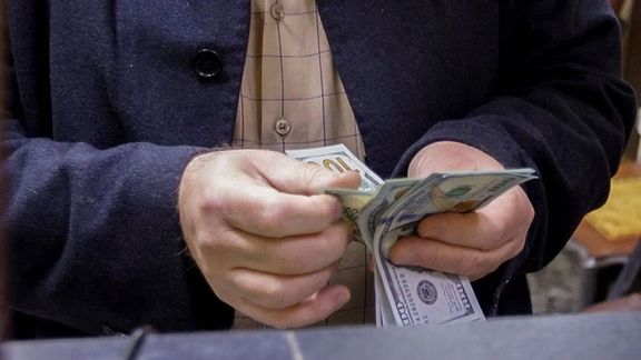 A man counts US dollars at a currency exchange shop in Baghdad, Iraq, January 23, 2023.