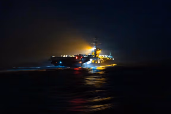 The Nimitz-class aircraft carrier USS Abraham Lincoln departs following a replenishment-at-sea during the Operation Epic Fury attack on Iran at an undisclosed location, March 18, 2026.