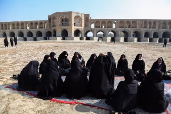 Families of protesting farmers sit on the dry bed of the Zayandeh Rud River in Iran’s Isfahan during a protest gathering in November 2021.