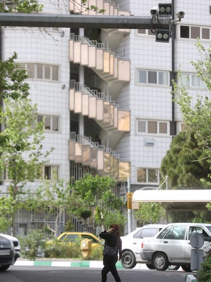 An Iranian woman walks without hijab under a surveillance camera in Tehran