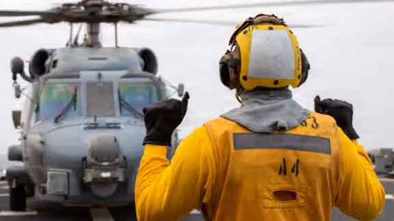 A US sailor signals to an MH-60R Sea Hawk helicopter aboard the USS John Paul Jones as the guided-missile destroyer enforces the US blockade against Iran, in an image posted by US Central Command on September 13, 2026.