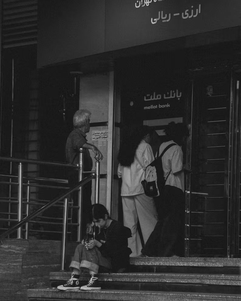 Photo shows people outside a branch of Iran's Mellat Bank during widespread banking service disruptions.