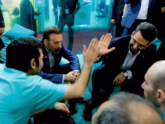 Former Minister of Communication and Information Mohammad Javad Azari Jahromi high-fiving a man from Arvan Cloud company as Mahmoud Vaezi, the Chief of Staff of former president Hassan Rouhani is looking (July 2019)