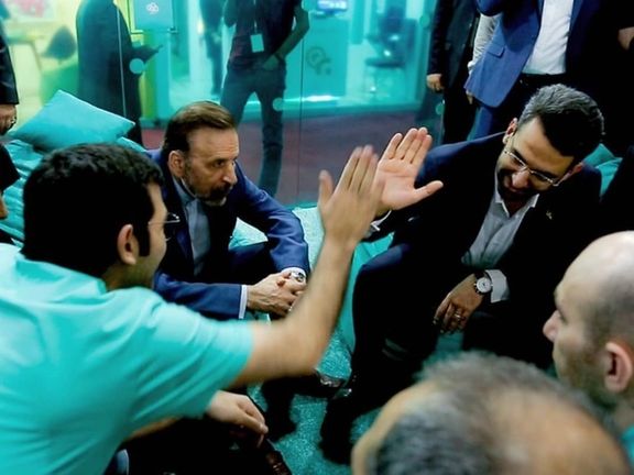 Former Minister of Communication and Information Mohammad Javad Azari Jahromi high-fiving a man from Arvan Cloud company as Mahmoud Vaezi, the Chief of Staff of former president Hassan Rouhani is looking (July 2019)