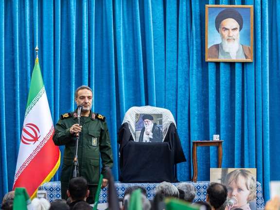 An IRGC commander speaks for a crowd gathering to honour the memory of Iran's slain supreme leader Ali Khamenei, with a picture of him resting on his seat, Tehran, May 7, 2026