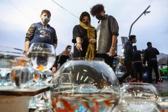 People look at goldfish displayed for sale at a street market ahead of Nowruz celebrations in Tehran.