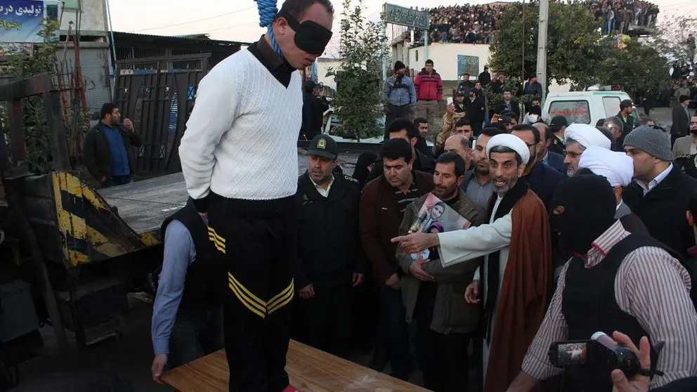 A blindfolded man stands on a platform moments before his public execution in Iran