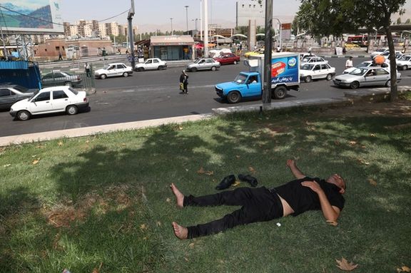 An Iranian man rests in the shade of a tree during the heat surge in Tehran, August 2, 2023.