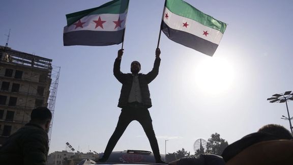 A man holds the Syrian opposition flag as they celebrate after Syria's army command notified officers on Sunday that President Bashar al-Assad's 24-year authoritarian rule has ended, a Syrian officer who was informed of the move told Reuters, following a rapid rebel offensive that took the world by surprise, in Aleppo, Syria December 8, 2024.