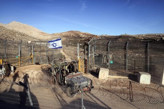 An Israeli military vehicle rides by the ceasefire line between the Israeli-occupied Golan Heights and Syria, as seen from Majdal Shams in the Golan Heights, December 15, 2024.