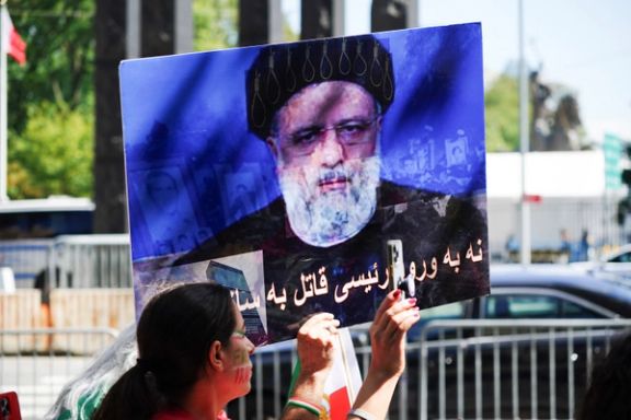 A demonstrator holds a placard with the image of Iran's President Ebrahim Raisi as Iranian Americans protest near the United Nations headquarters during Raisi's visit to New York City, September 19, 2023.