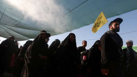 Iranian Shi'ite pilgrims walk on a road, after entering Iraq through the Zurbatia border crossing between Iran and Iraq, as they head towards Iraq's holy city of Kerbala to attend the holy Shi'ite ritual of Arbaeen, in Zurbatia, Iraq August 14, 2024.