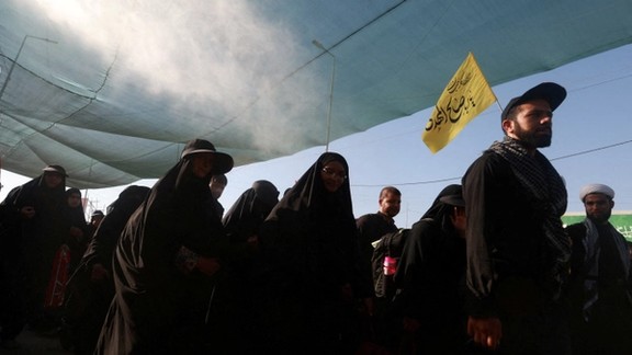 Iranian Shi'ite pilgrims walk on a road, after entering Iraq through the Zurbatia border crossing between Iran and Iraq, as they head towards Iraq's holy city of Kerbala to attend the holy Shi'ite ritual of Arbaeen, in Zurbatia, Iraq August 14, 2024.