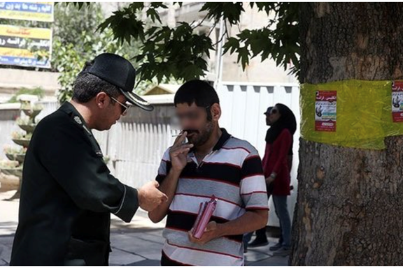 Police stopping a man on the street for smoking during the month of Ramadhan