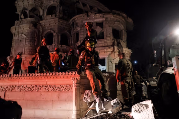 Rescue and security personnel operate following the impact of missiles fired from Iran on a residential building in Tamra, northern Israel, June 15, 2025.
