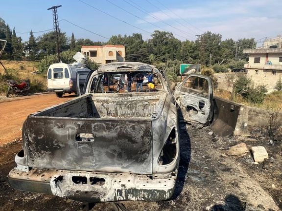 Media personnel stand near a damaged vehicle in the aftermath of what Syrian state media reported was an Israeli strike in Hama, Syria September 9, 2024.