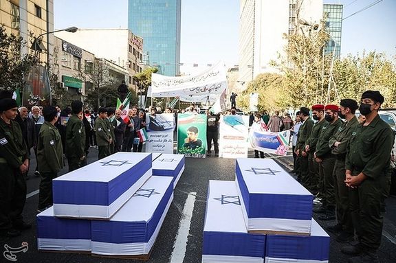 Symbolic coffins draped in Israeli flags are carried during a rally in Tehran marking the anniversary of the 1979 US embassy takeover (November 4, 2025)