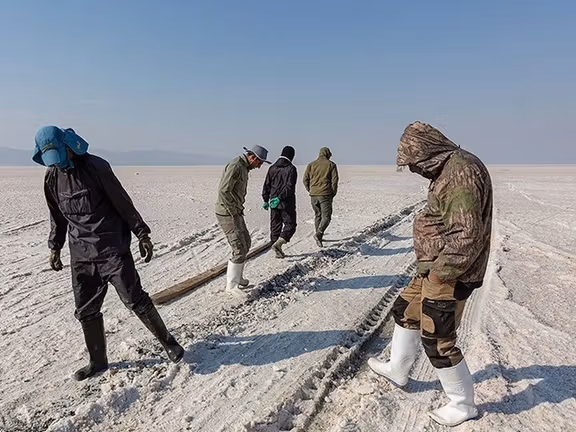 People walk across the dried basin of Lake Urmia.