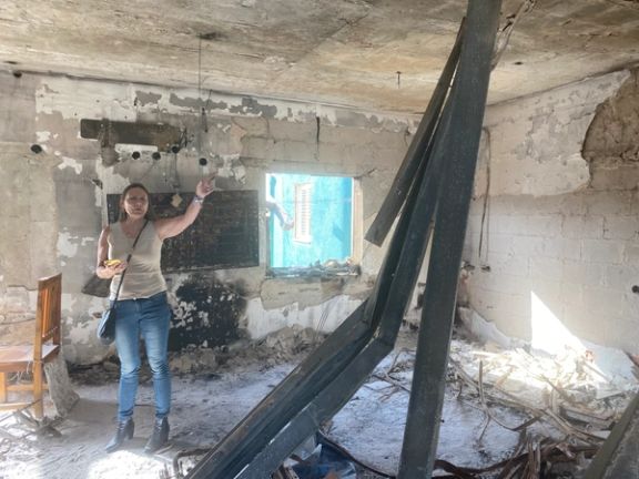 Daniel's mother, Rita, showing burnt out homes in Nir Oz.