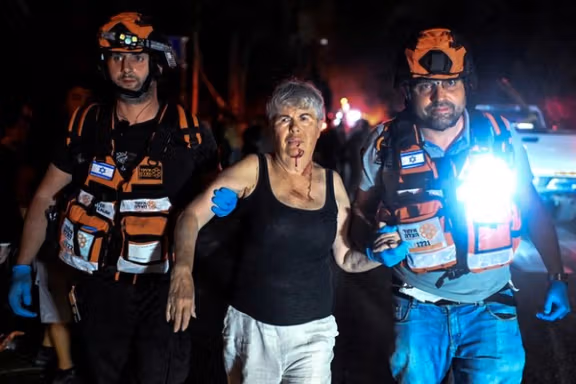 Rescue personnel assist an injured woman at an impact site following a missile attack from Iran on Israel, in Haifa, Israel, June 15, 2025.