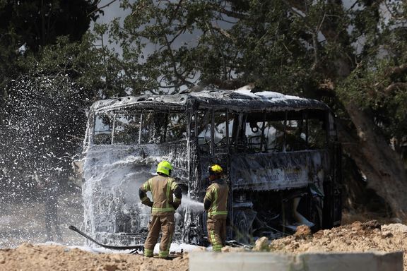 Firefighters work to extinguish a fire on a bus following a missile attack from Iran, in Herzliya, Israel, June 17, 2025.