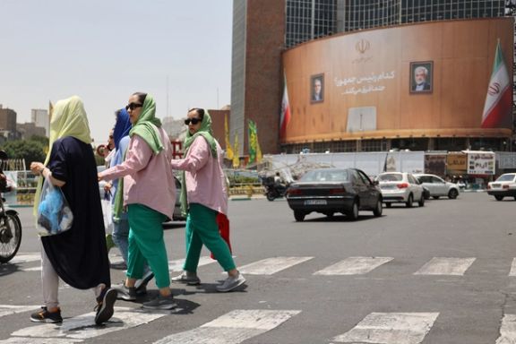 People walk past a billboard with pictures of presidential candidates Masoud Pezeshkian and Saeed Jalili on a street in Tehran, Iran, July 4, 2024