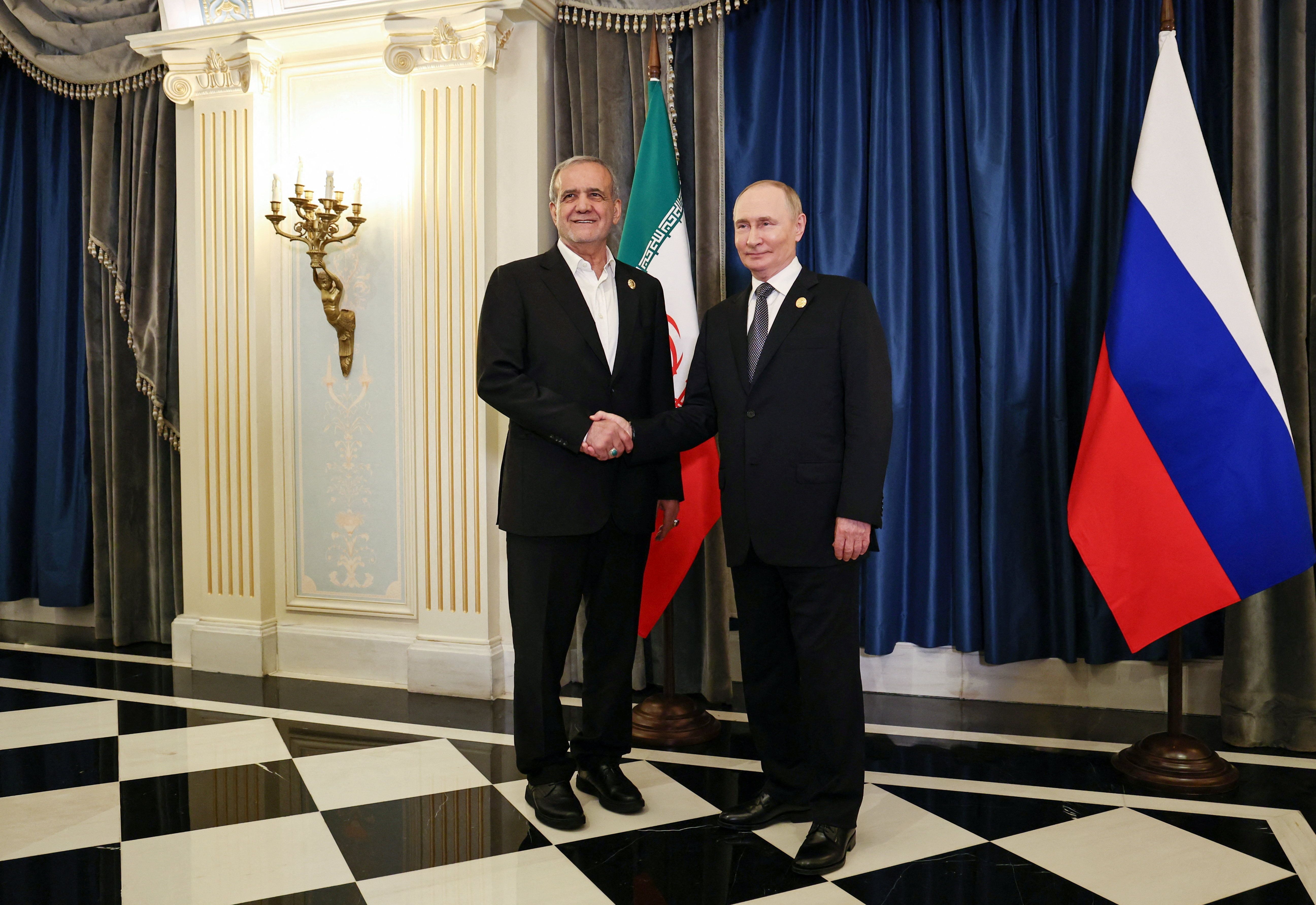 Russia's President Vladimir Putin shakes hands with Iran's President Masoud Pezeshkian during a meeting on the sidelines of the Shanghai Cooperation Organisation (SCO) summit in Tianjin, China, September 1, 2025. 