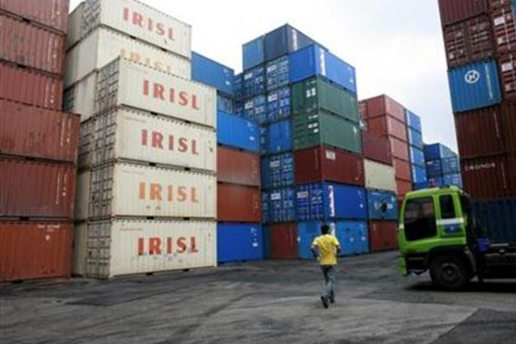 A truck driver walks past a stack of IRISL containers at a depot in northern Singapore February 4, 2012.