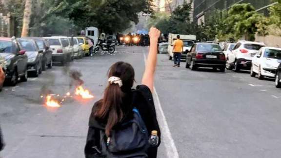 A young woman without headscarf facing the anti-riot police in Rasht, Sept, 19, 2022