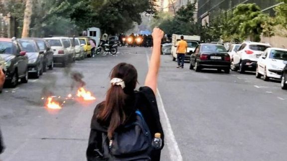 A young woman without headscarf facing the anti-riot police in Rasht, Sept, 19, 2022