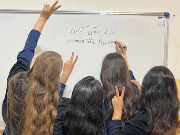 Iranian students write 'Woman, Life, Freedom' on the board with uncovered hair (File photo)